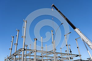 Construction crane towering over structural steel framing for new building
