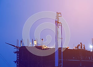 Construction crane truck working on structure at night