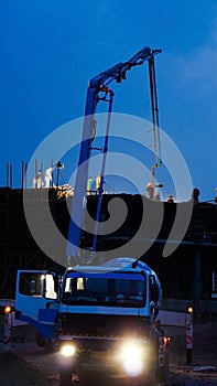 Construction crane truck working on structure at night