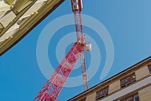 Construction crane between two houses in the city