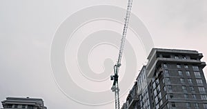 Construction crane works on building site. High rise residential complex under construction. Construction of apartment building in