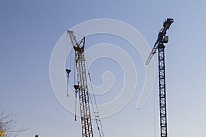 Construction cranes on the blue sky background