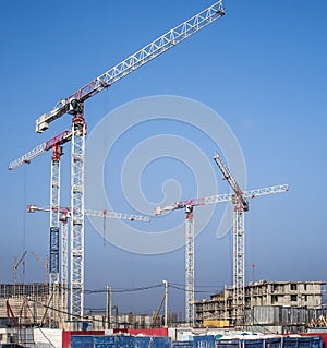 Construction cranes on a blue sky background