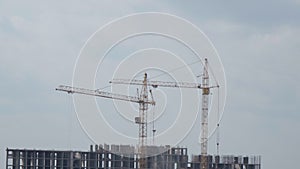 Construction cranes, construction site. Housing construction, apartment block in city. Copy Space