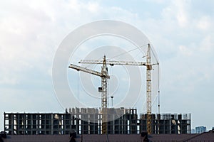 Construction cranes, construction site. Housing construction, apartment block in city. Copy Space