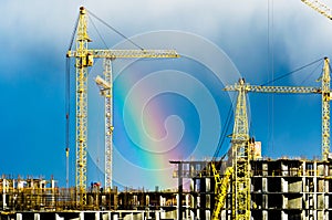 Construction cranes industrial city rain rainbow