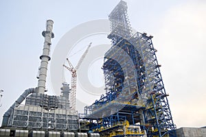 Construction with cranes of a large blue chemical plant at an oil refinery