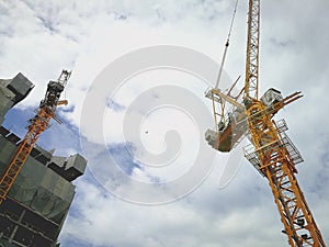 Construction cranes machine against sky background. Under construction.