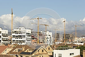 construction cranes between new buildings and others under construction real estate speculation image