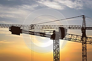 Construction cranes at sunset
