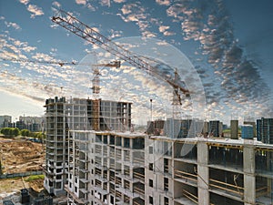 Construction cranes and top of the building with construction workers