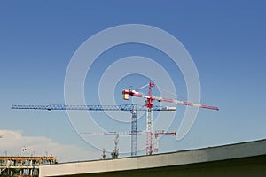 Construction cranes view over blue sky