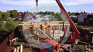 Construction crew installing roof. Clip. Top view of installation of part of wooden roof with crane and construction