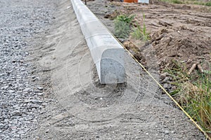 Construction of curbs on the edge of a sidewalk with the help of a masonry cord