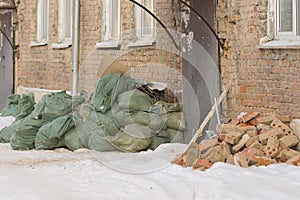 Construction debris in bags near the front door of an old apartment building
