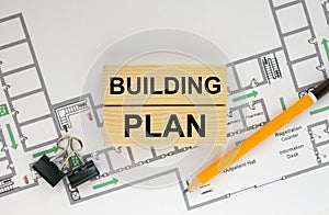 Construction drawings and wooden bars with text Bulding Plan and paper clips