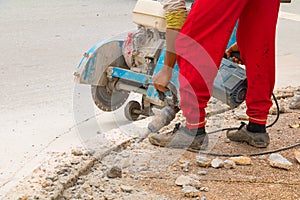 Construction drilling repair worker on road surface with heavy duty machine drill motion