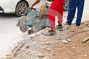 Construction drilling repair worker on road surface with heavy duty machine drill motion