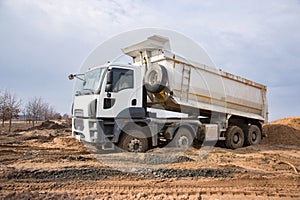 Construction dump truck performs excavation work on a construction site