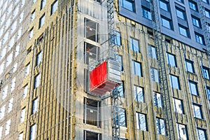 Construction elevator outside the facade of a multi-storey building under construction