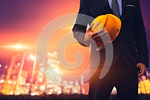 Construction engineer in business suit  Holding Yellow Safety hard hat Security Equipment on Construction Site. Civil Construction