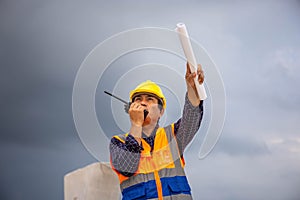 Construction engineer checking project at the building site, Architect with a blueprints at a construction site, Foreman worker in