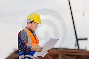 Construction engineer checking project at the building site, Architect with a blueprints at a construction site, Foreman worker in