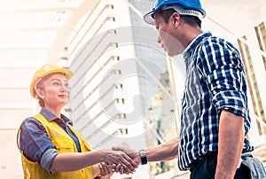 Construction and engineer concept. Construction worker in protective uniform shaking hands meeting