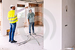 Construction engineer discussing with architect worker at indoor building site