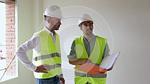 Construction engineer discussing with architect worker at indoor building site