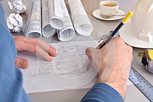 Construction engineer drawing a house on his office desk closeup