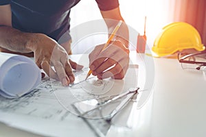 Construction engineer working at blueprint to build large commercial buildings
