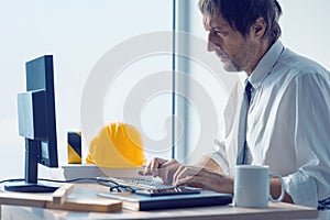 Construction engineer working on desktop computer using CAD soft