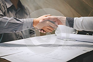 Construction engineering or architect discuss a blueprint while checking information on drawing and sketching, meeting for