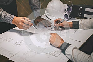 Construction engineering or architect discuss a blueprint while checking information on drawing and sketching, meeting for