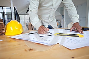 Construction engineering. Architect drawing blueprints and engineering tools on workplace
