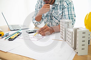 Construction engineers are checking blueprints and calculating their accuracy after receiving plans from architect in order start