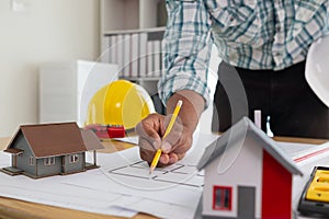 Construction engineers are checking blueprints and calculating their accuracy after receiving plans from architect in order start