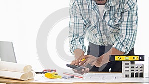 Construction engineers are checking blueprints and calculating their accuracy after receiving plans from architect in order start