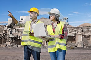 Construction engineers with laptop and tablet inspecting industrial facility photo