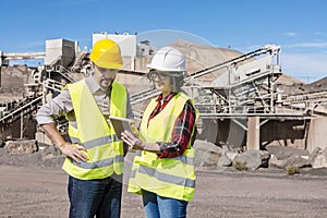 Construction engineers with tablet discussing draft photo