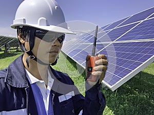 Construction engineers use a walkie-talkie to communicate with technicians in solar power plants