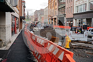 Construction equipment during road works in an urban environment between tall buildings