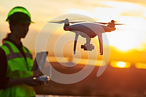 Drone inspection. Operator inspecting construction building site flying with drone. sunset photo