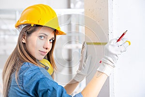 Construction female worker using measuring tape