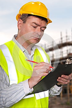 Construction foreman checks clipboard photo