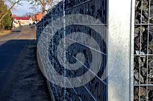 Construction of a gabion retaining wall, as part of the fencing home coarser gravel filled poured between two wire slabs. stones p