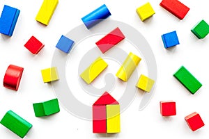 Construction game for kids. Wooden building blocks, toy bricks on white background top view