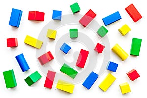 Construction game for kids. Wooden building blocks, toy bricks on white background top view