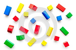 Construction game for kids. Wooden building blocks, toy bricks on white background top view